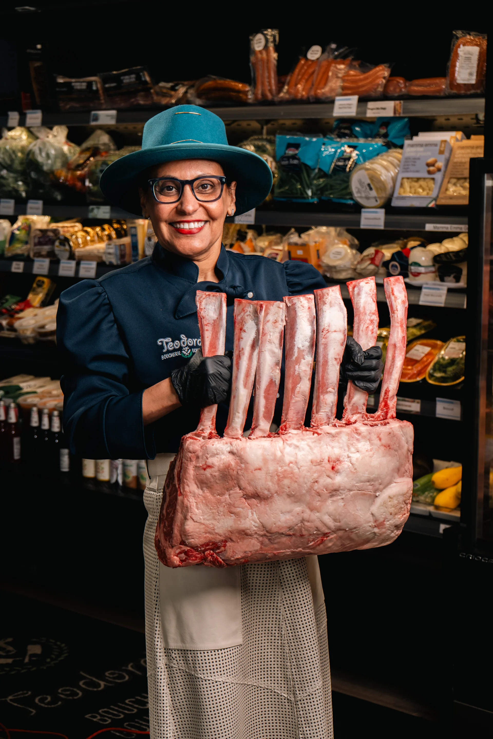 Teodora in the butcher shop holding a prepared cut of beef