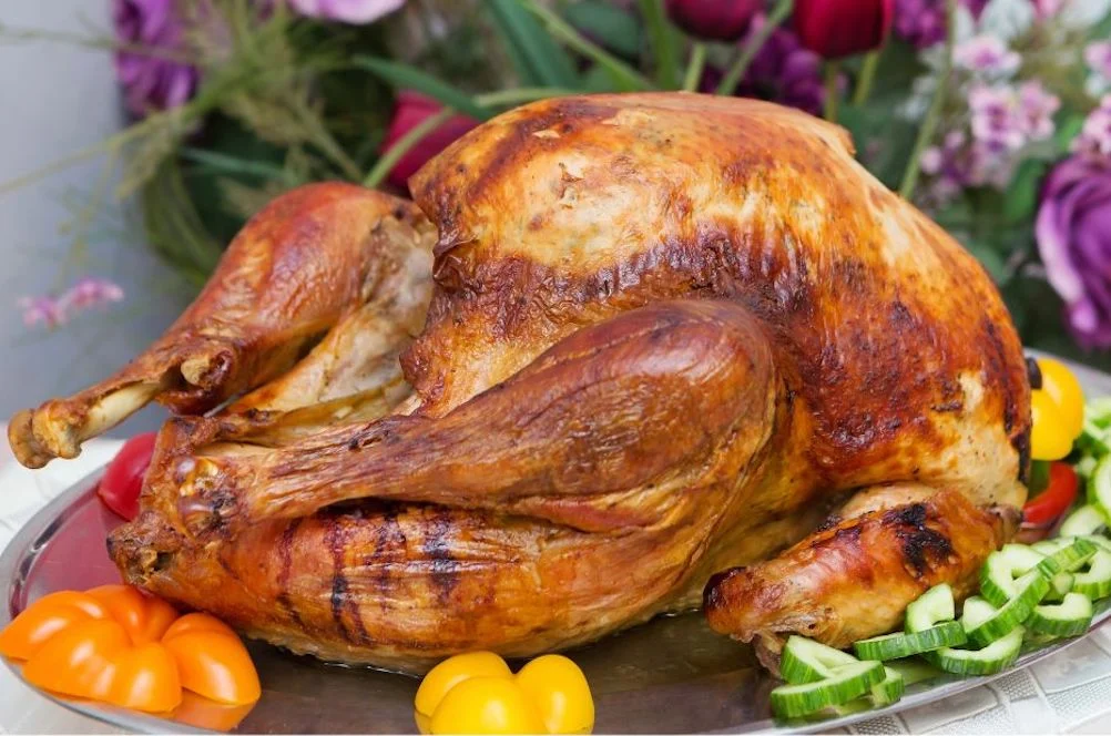 Golden roasted whole turkey on a platter with vegetables